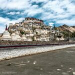 white and brown concrete building near body of water under blue sky during daytime