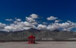 a red fire hydrant sitting in the middle of a desert